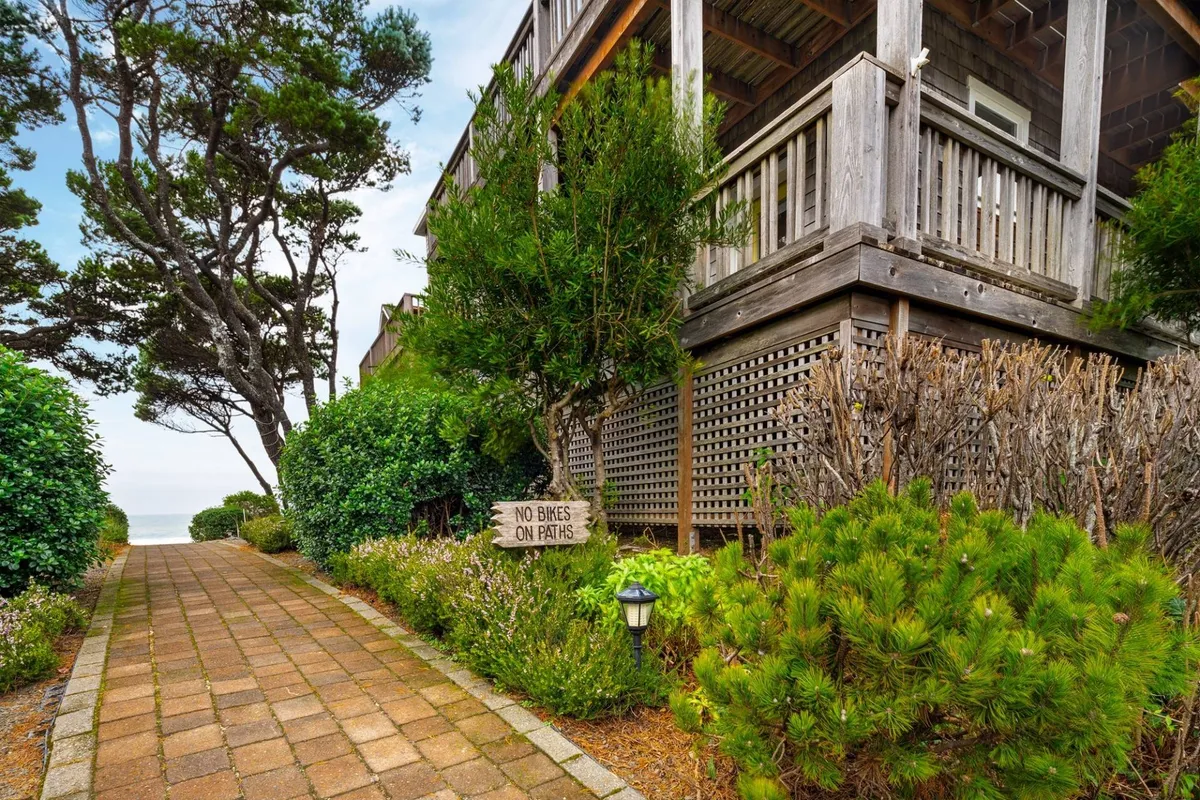 A wide pathway meanders through well-landscaped communal areas with clear signage and attractive building facades in view. The tranquil mood and photo opportunities suggest a well-cared-for neighborhood that encourages strolls and quiet enjoyment.
